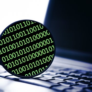 advanced system repair system optimizers review magnifying glass on laptop binary code on the glass